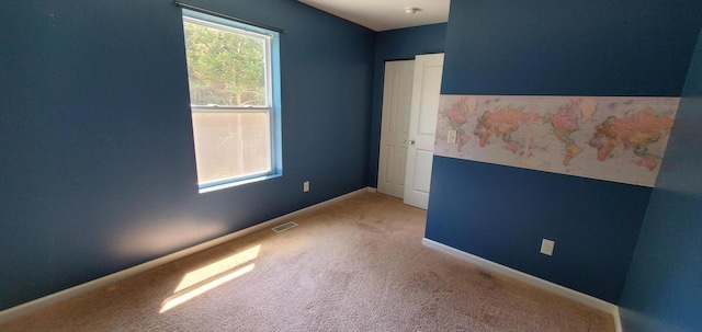 spare room featuring light colored carpet