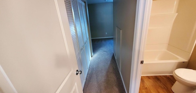 bathroom with hardwood / wood-style floors, toilet, and tub / shower combination