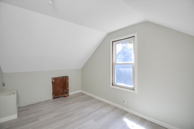 additional living space featuring lofted ceiling and light wood-type flooring