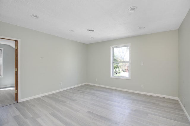 unfurnished room featuring a textured ceiling and light wood-type flooring