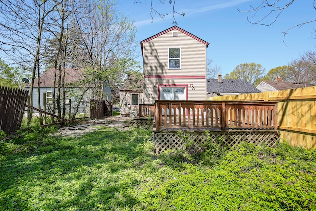 rear view of property with a lawn and a wooden deck