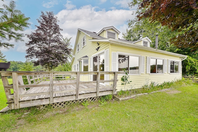 view of property exterior with a lawn and a wooden deck