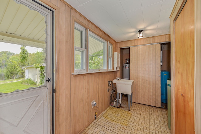 entryway with wooden walls and water heater