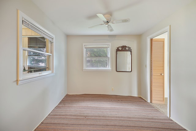 empty room featuring ceiling fan and light carpet