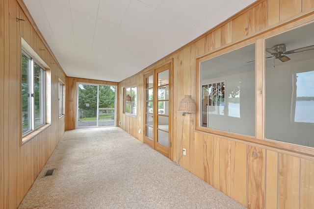 unfurnished sunroom featuring a water view