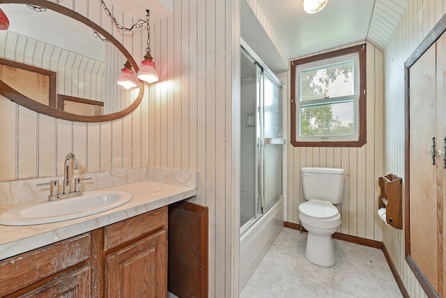 full bathroom featuring tile patterned floors, vanity, enclosed tub / shower combo, toilet, and wood walls