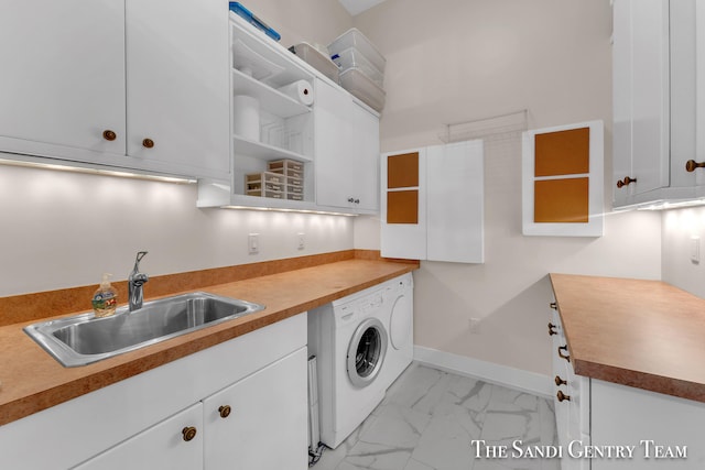 laundry area featuring cabinets, washer / dryer, and sink