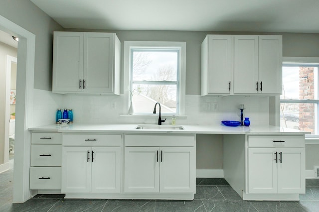 kitchen with decorative backsplash, white cabinetry, a healthy amount of sunlight, and sink