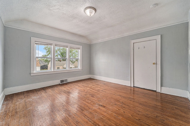 unfurnished room with a textured ceiling, lofted ceiling, and hardwood / wood-style flooring