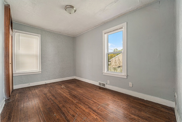 spare room featuring dark hardwood / wood-style flooring and crown molding