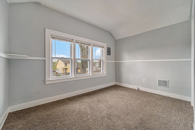 carpeted spare room featuring vaulted ceiling