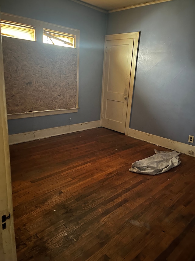 unfurnished room with dark hardwood / wood-style flooring and ornamental molding