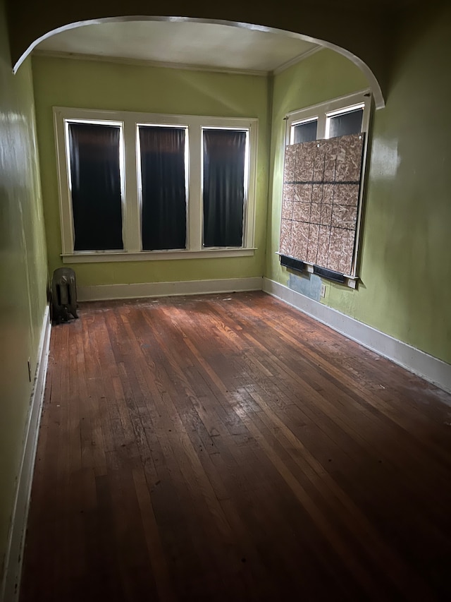 unfurnished room with crown molding and dark hardwood / wood-style floors