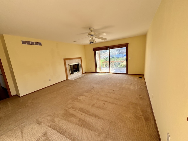 unfurnished living room with ceiling fan, light colored carpet, and a fireplace