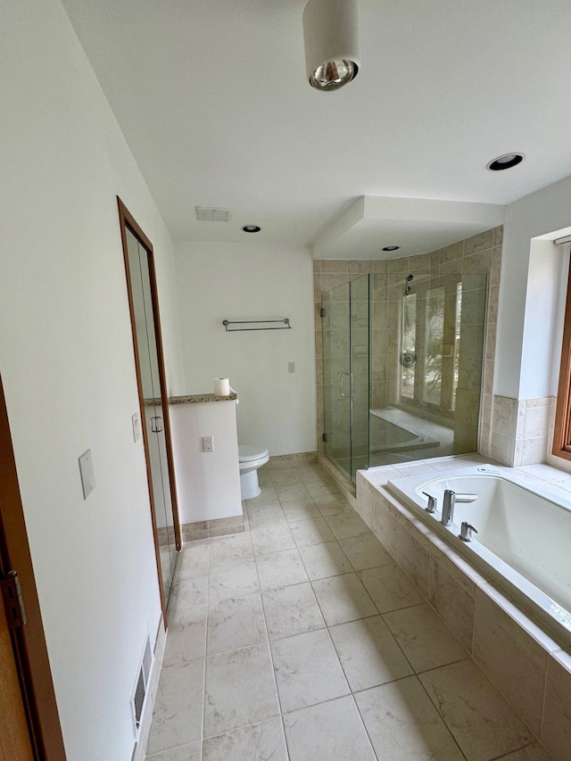 bathroom with tile patterned floors, shower with separate bathtub, and toilet