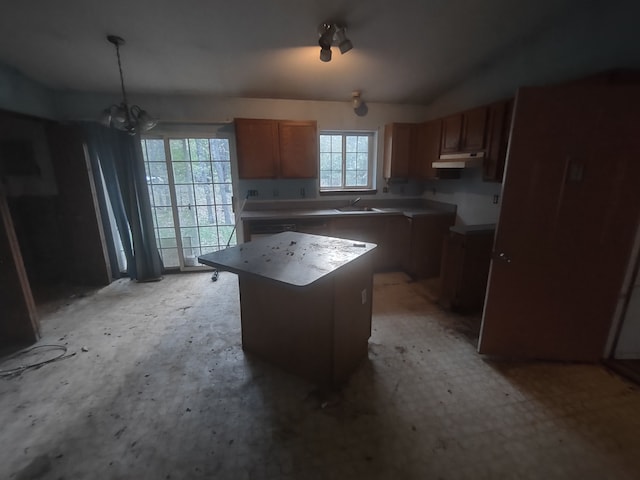 kitchen featuring sink, a kitchen island, a chandelier, and decorative light fixtures