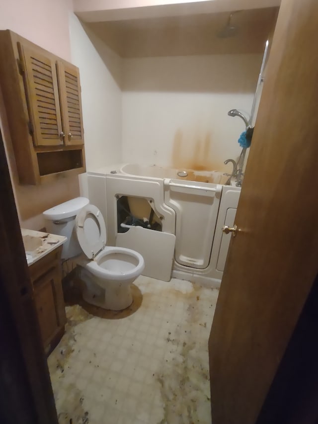 bathroom with vanity, a bathtub, and toilet