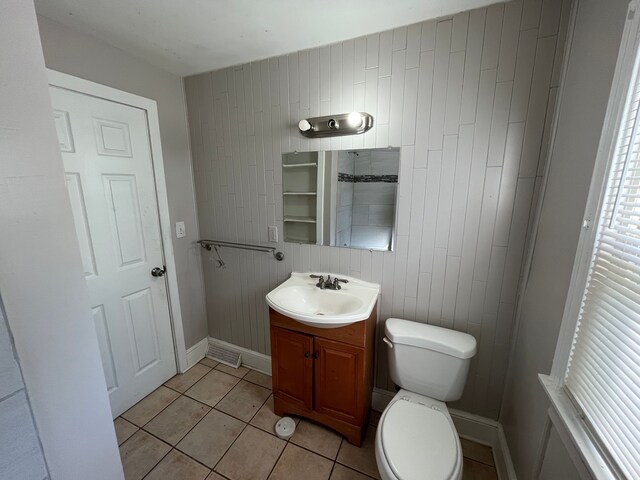 bathroom with tile patterned floors, wood walls, vanity, and toilet