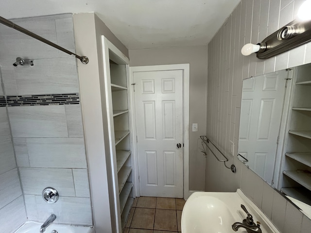 bathroom with tile patterned flooring, washtub / shower combination, and wooden walls