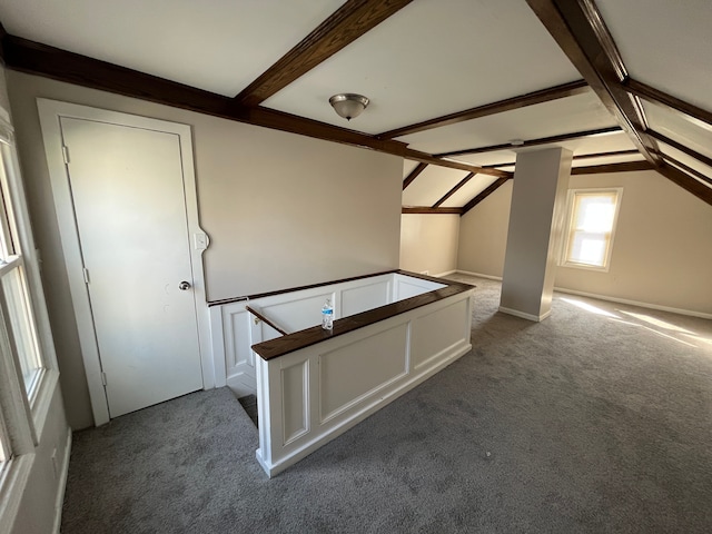 additional living space featuring carpet floors and lofted ceiling with beams