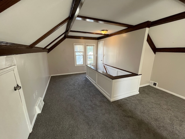 additional living space with lofted ceiling with beams and dark colored carpet