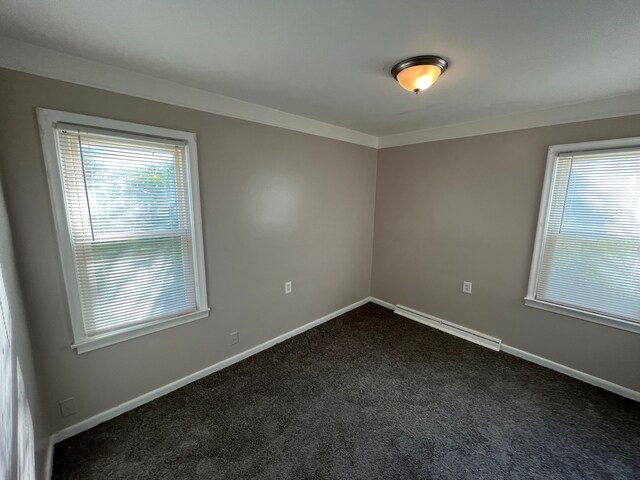 carpeted empty room with ornamental molding and a baseboard heating unit