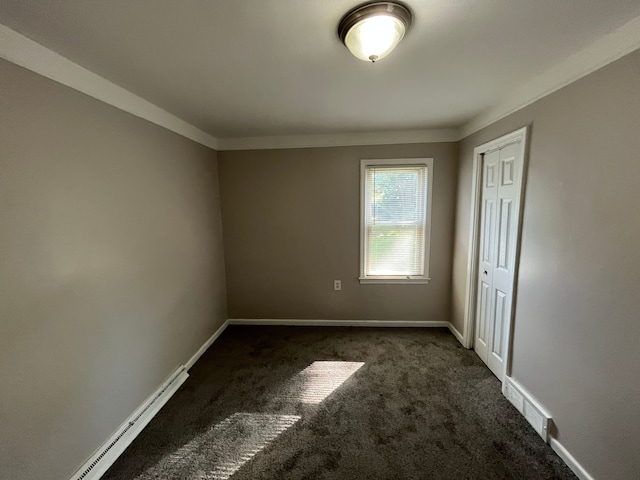 carpeted spare room featuring baseboard heating and crown molding