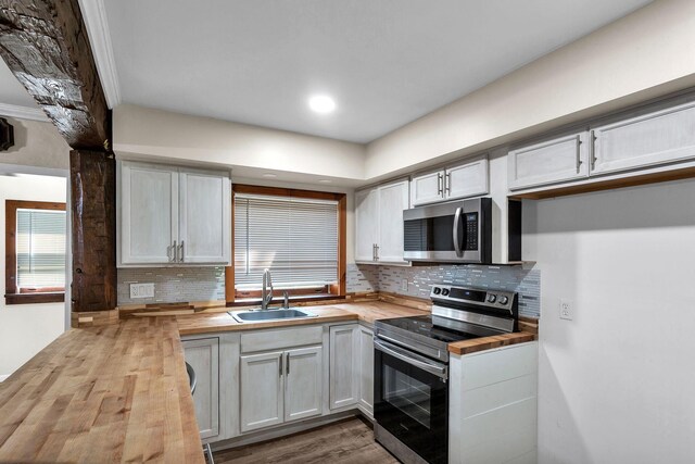 kitchen featuring sink, white cabinets, stainless steel appliances, and wood counters