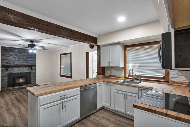 kitchen featuring white cabinetry, stainless steel dishwasher, and wood counters