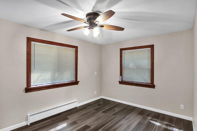 empty room with ceiling fan, dark wood-type flooring, and a baseboard heating unit