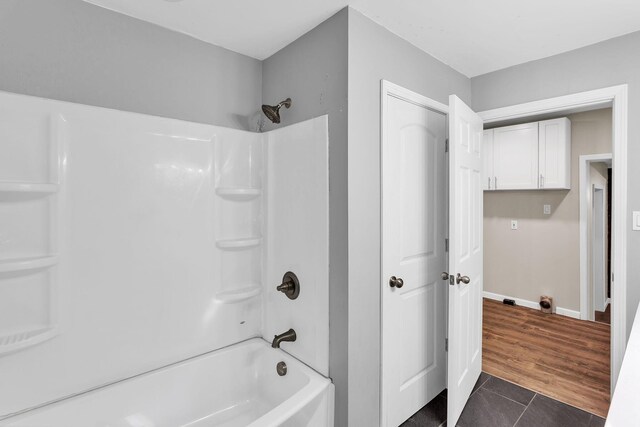 bathroom featuring wood-type flooring and shower / bathtub combination