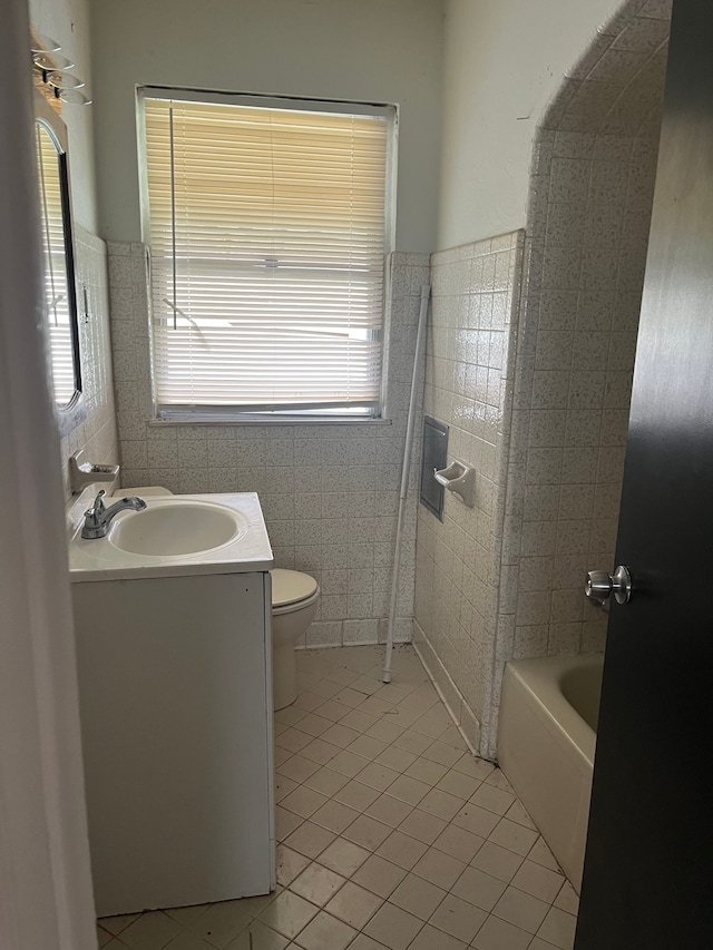 bathroom featuring tile patterned flooring, a healthy amount of sunlight, tile walls, and toilet