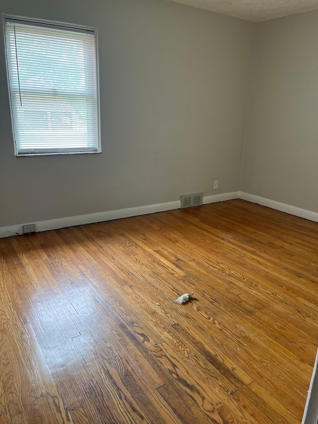 unfurnished room featuring hardwood / wood-style floors and a textured ceiling