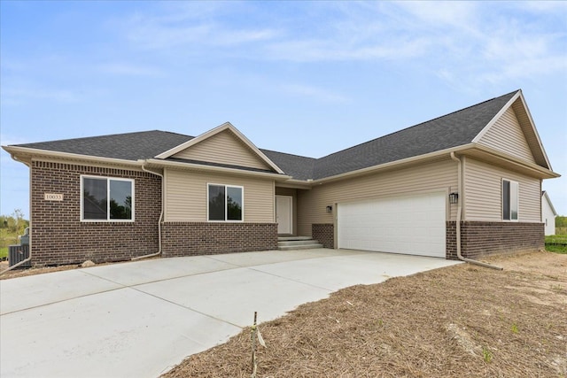 single story home featuring a garage and central AC unit