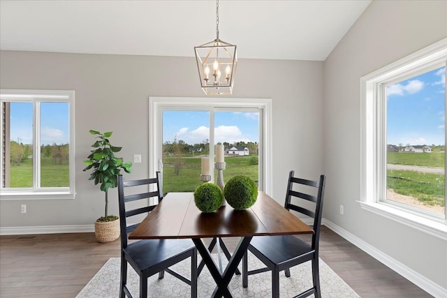 dining area featuring dark wood-type flooring and a chandelier