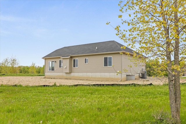 back of house with a yard and central air condition unit