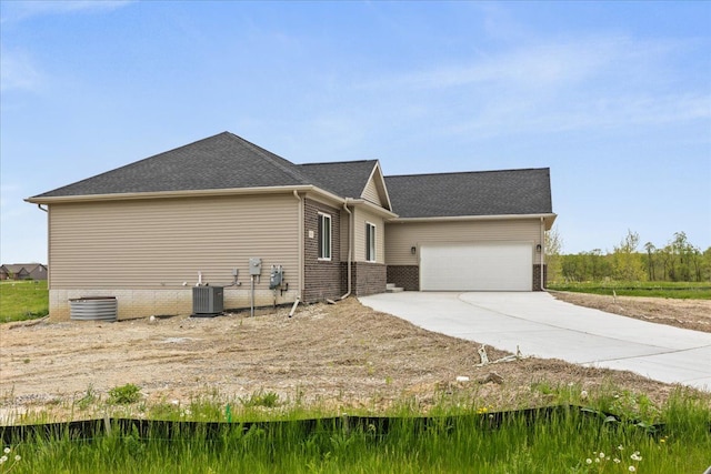 view of home's exterior with a garage and central AC