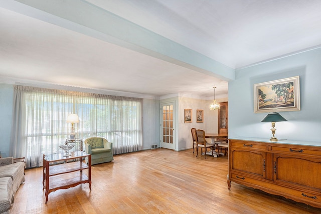 living room with light wood-type flooring and an inviting chandelier