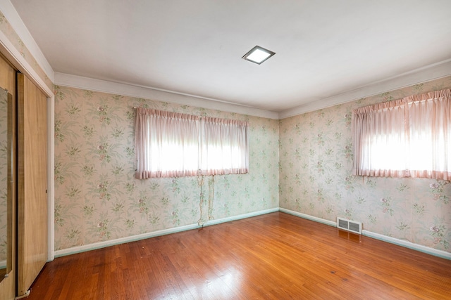 empty room featuring crown molding and hardwood / wood-style floors