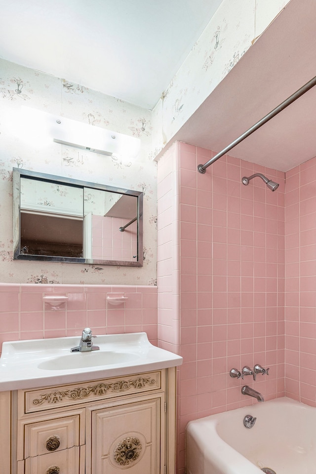 bathroom with vanity, tile walls, and tiled shower / bath