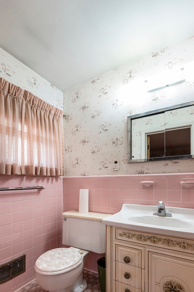 bathroom with vanity, tile walls, and toilet