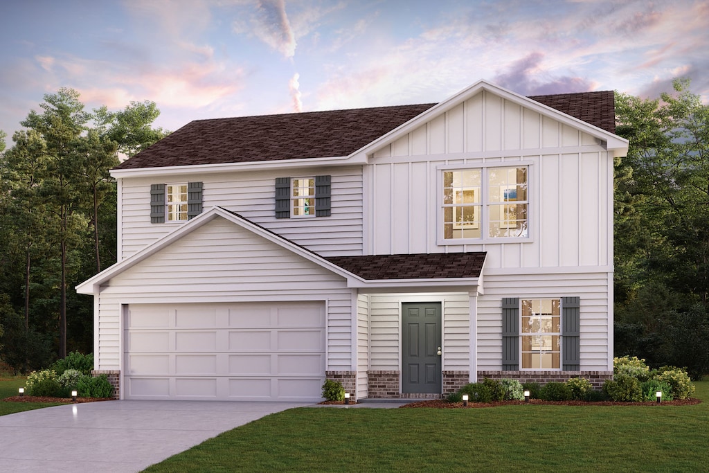 view of front of property with a garage and a lawn