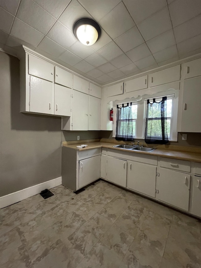 2734 Cumings Ave, Flint, MI 48503 - kitchen featuring white cabinets and a paneled ceiling