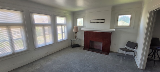 living room with carpet, a wealth of natural light, and a brick fireplace