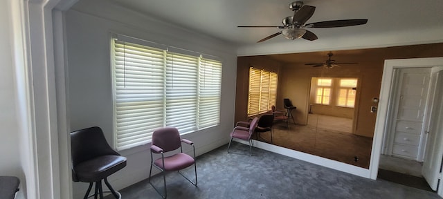 sitting room with dark carpet and ceiling fan