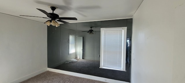 carpeted spare room featuring ceiling fan