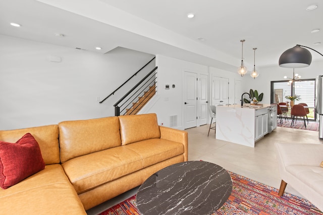 living room with a notable chandelier and sink