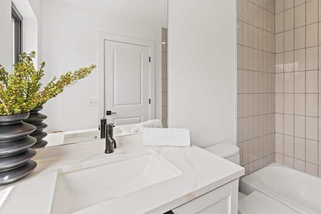 full bathroom with vanity, toilet, and tiled shower / bath combo