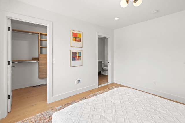 bedroom featuring a closet, light hardwood / wood-style flooring, and ensuite bathroom