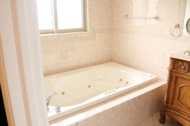 bathroom with tile patterned floors, a relaxing tiled tub, and vanity